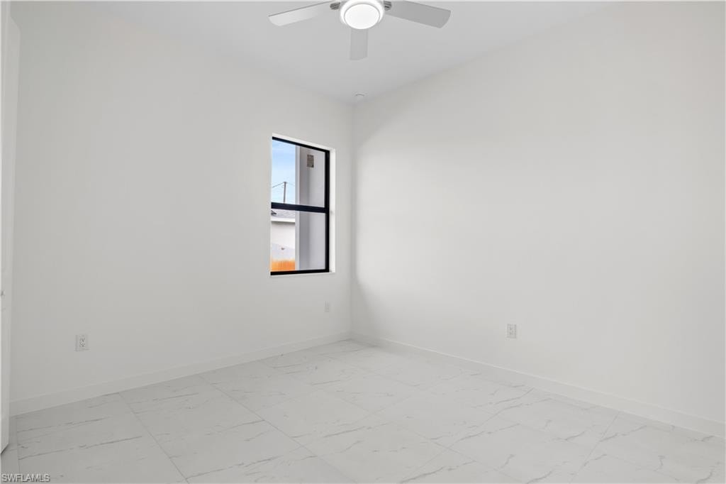 Unfurnished room featuring baseboards and light marble finish floors