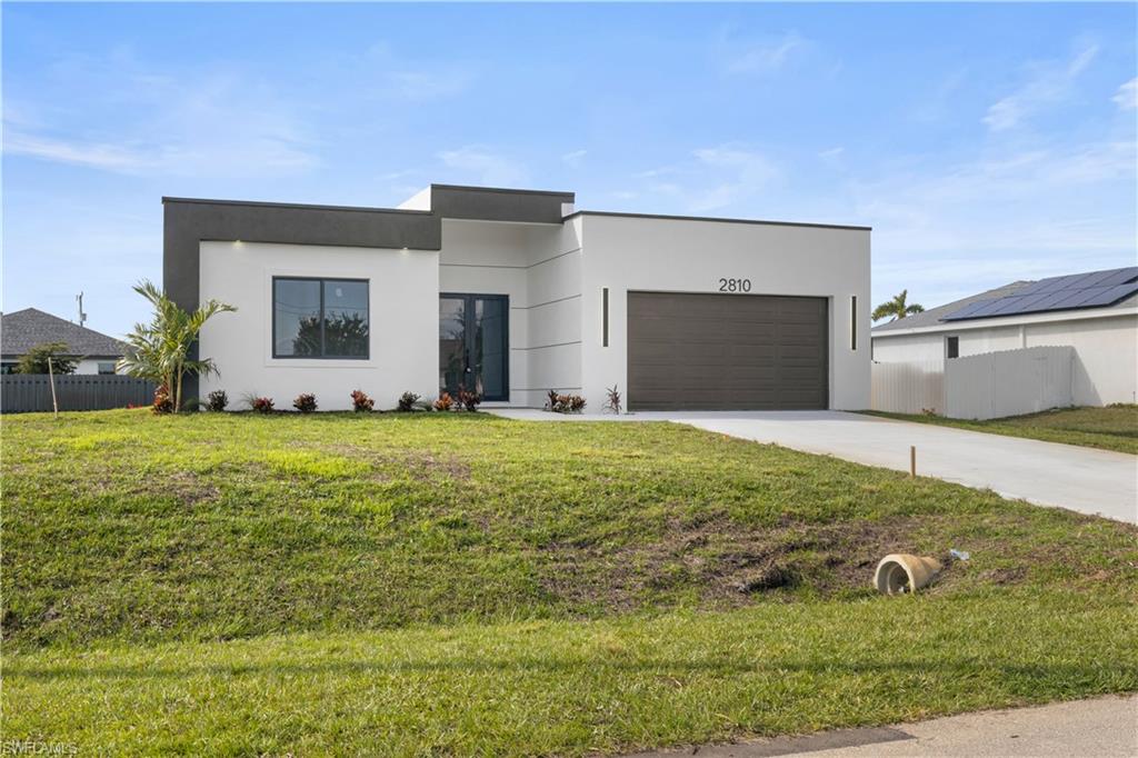 Contemporary home with concrete driveway, stucco siding, and a garage