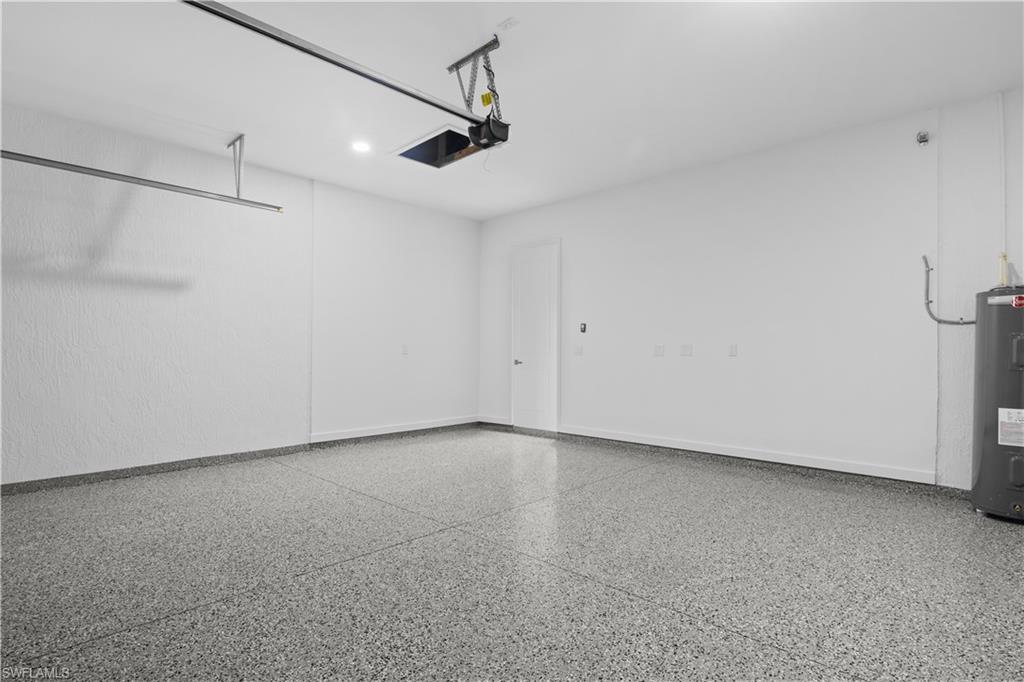 Garage with electric water heater and baseboards