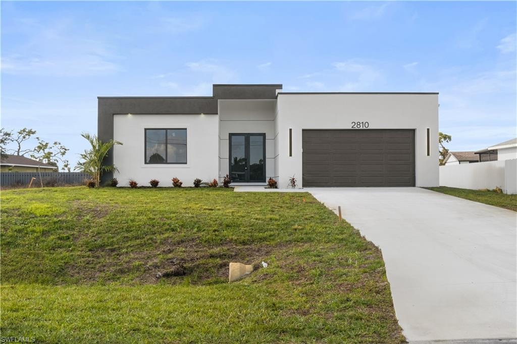 Contemporary home featuring driveway, stucco siding, and an attached garage
