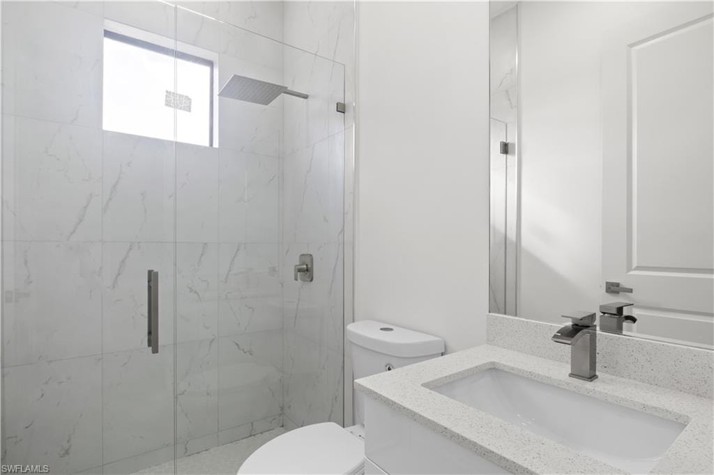 Full bath with vanity and a marble finish shower
