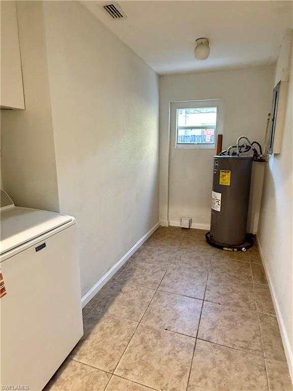 Laundry area with light tile patterned flooring, washer / clothes dryer, and water heater