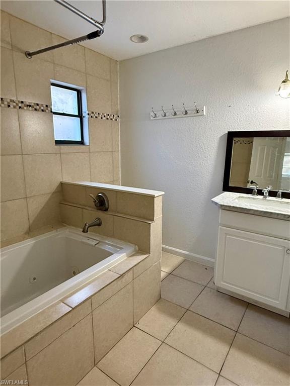 Bathroom featuring vanity, a combined bath / shower with jetted tub, a textured wall, and light tile patterned floors