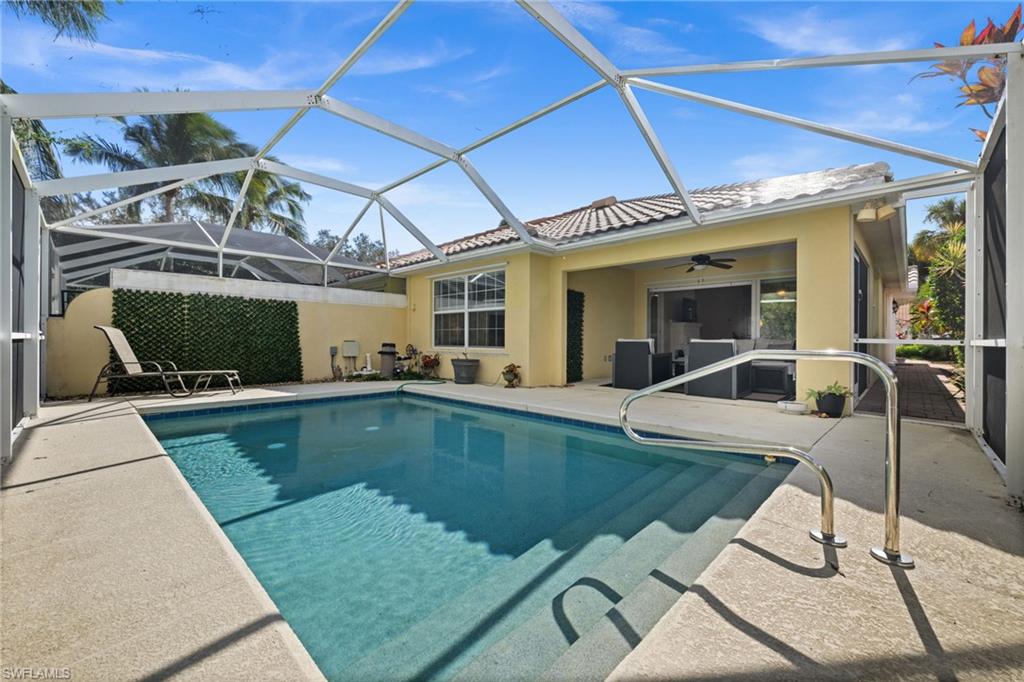 Swimming pool featuring a sunroom, a patio area, and glass enclosure