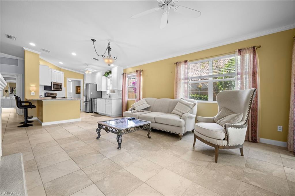 Living area featuring a ceiling fan, ornamental molding, recessed lighting, and vaulted ceiling