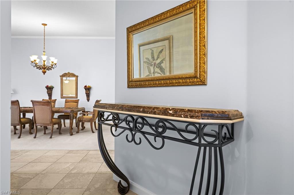 Hallway with ornamental molding and a chandelier