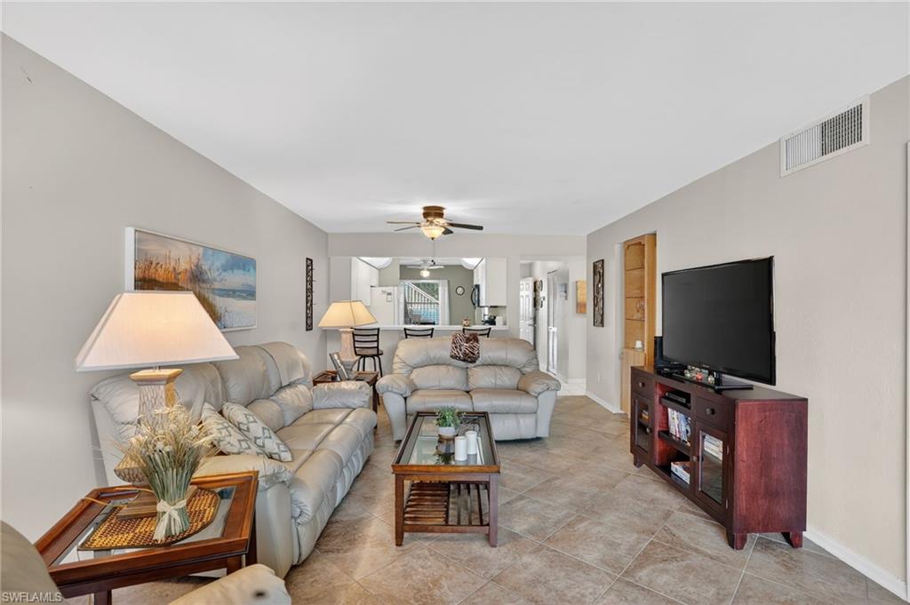 Living room with a ceiling fan and light tile patterned floors