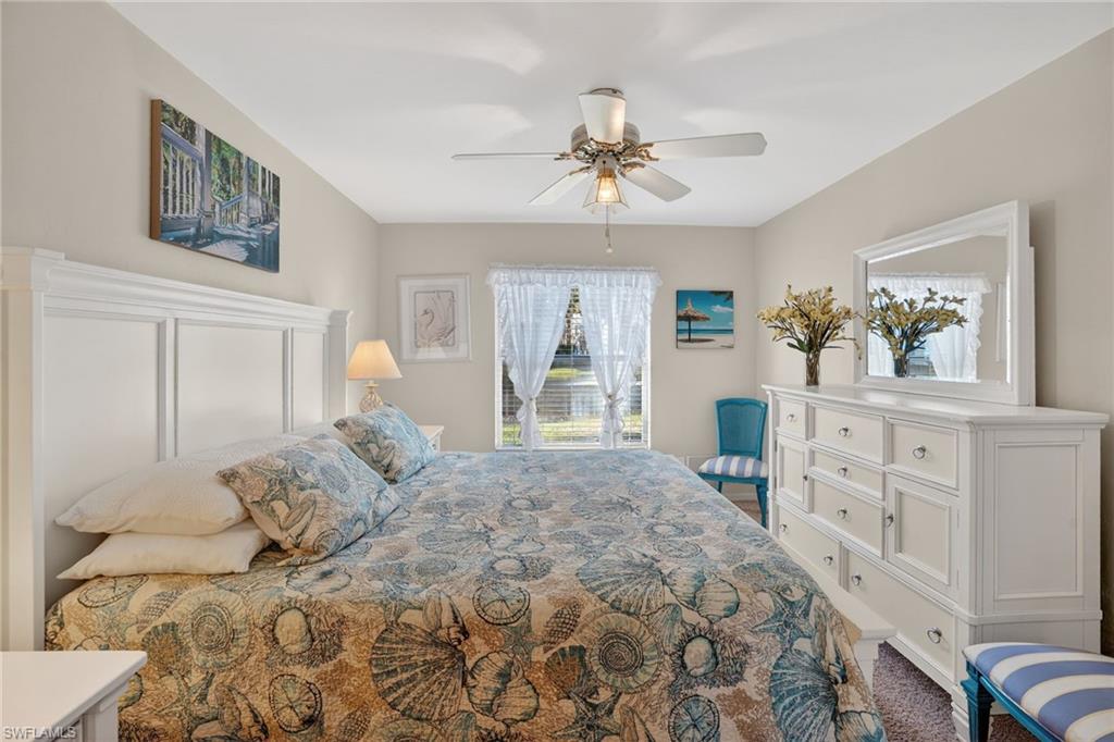 Carpeted bedroom featuring a ceiling fan