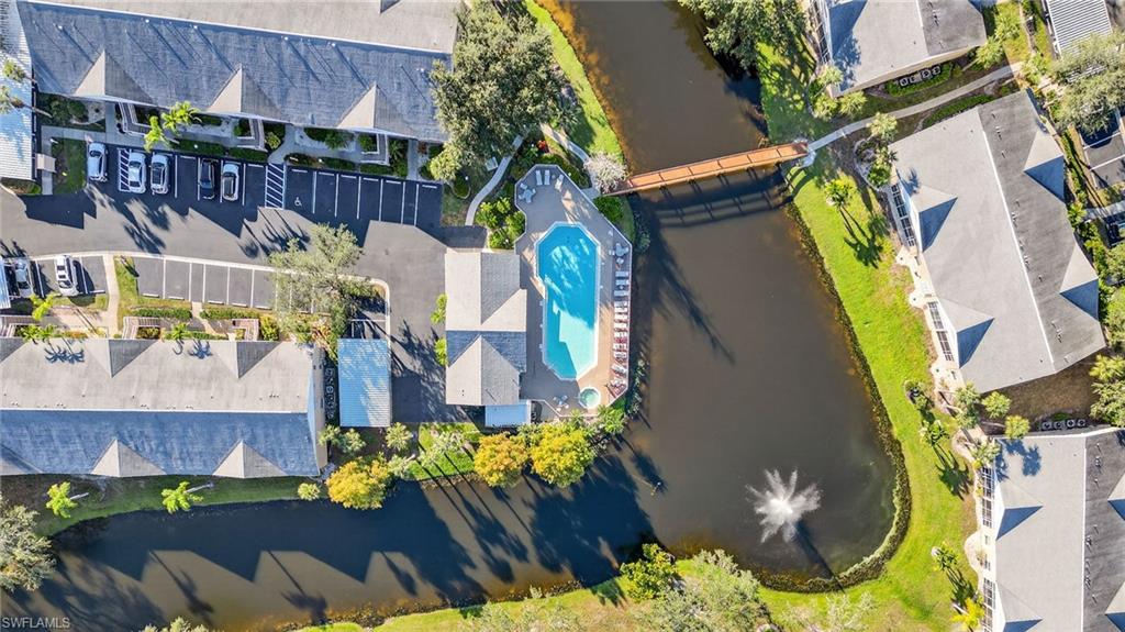Drone / aerial view of a nearby body of water and a pool