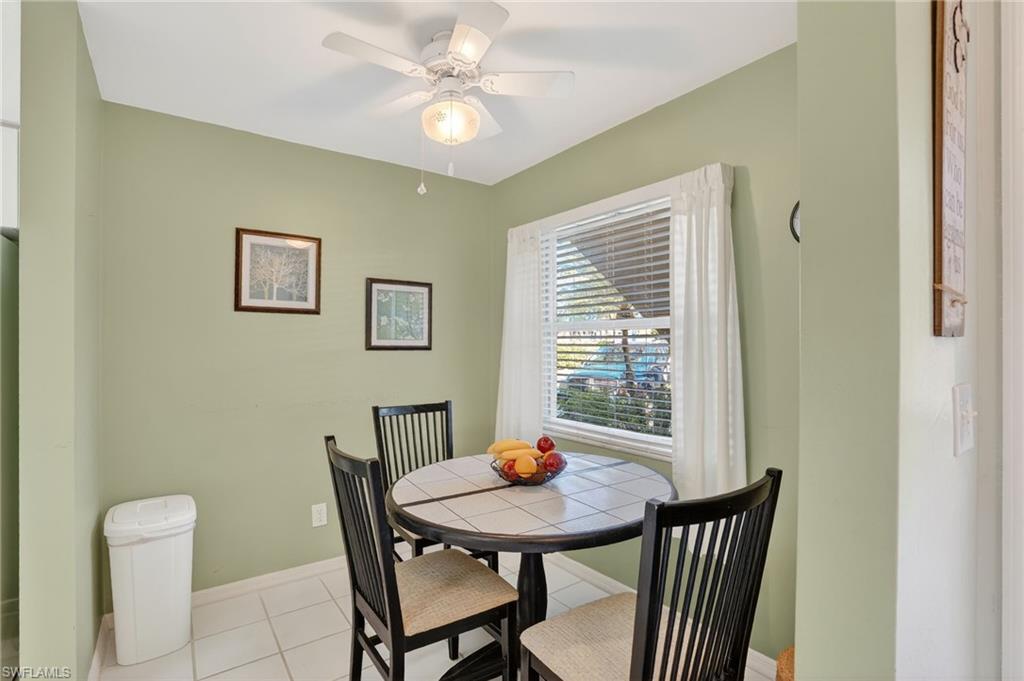 Dining area with light tile patterned flooring and a ceiling fan