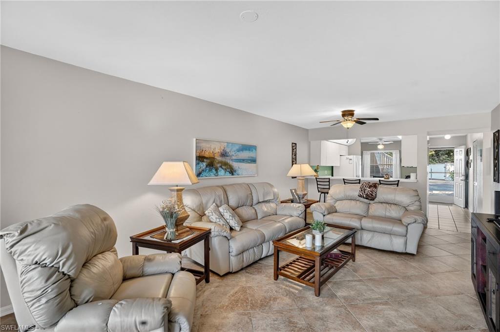 Living area featuring ceiling fan and light tile patterned flooring