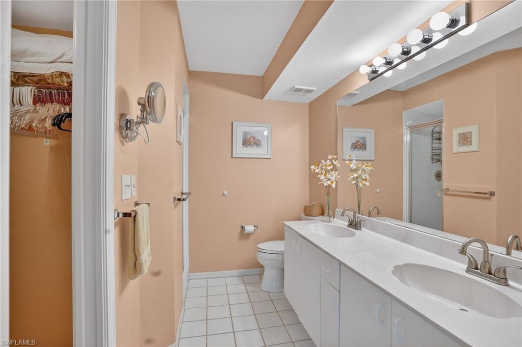 Full bathroom with double vanity, a shower stall, and light tile patterned floors