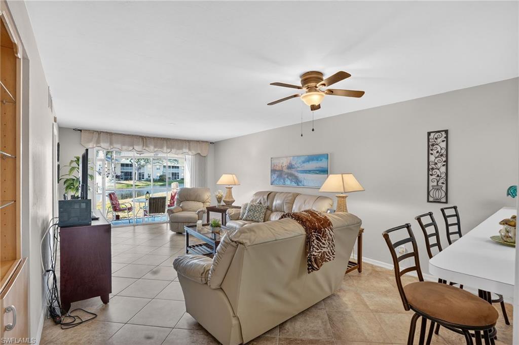 Living room with light tile patterned floors and a ceiling fan