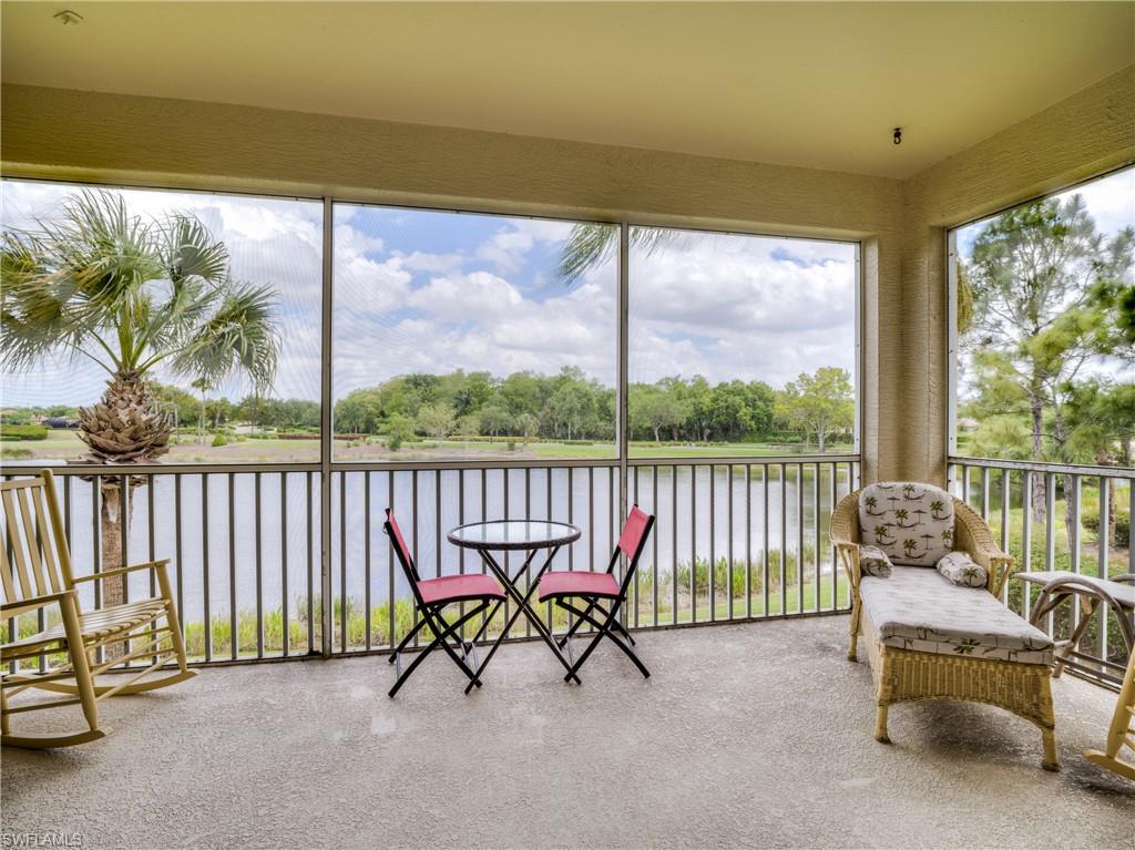 Sunroom with a water view, carpet floors, view of scattered trees, and healthy amount of natural light