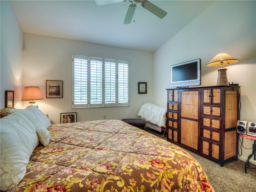 Carpeted bedroom with a ceiling fan