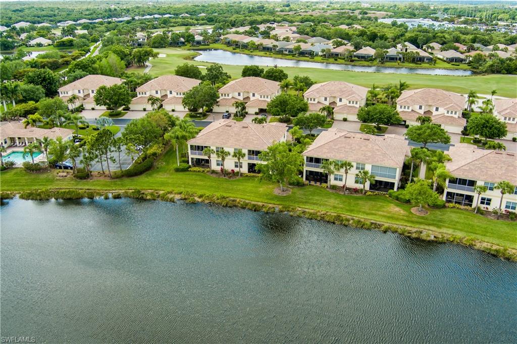 Aerial perspective of suburban area featuring a large body of water and a golf club