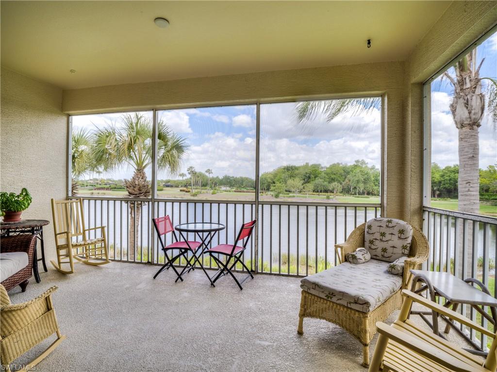 Sunroom featuring a textured wall, a water view, and carpet flooring