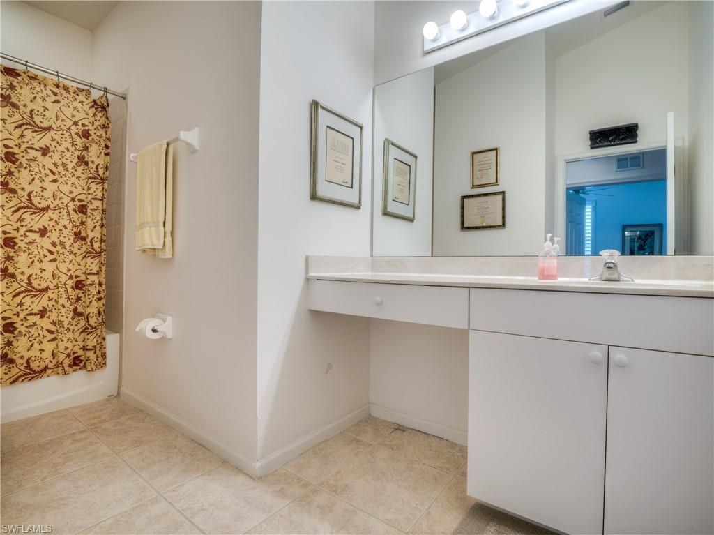 Bathroom featuring vanity, shower / tub combo with curtain, and light tile patterned floors