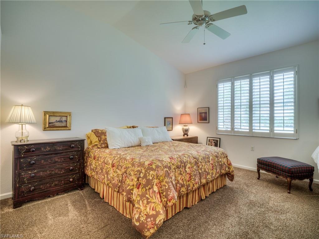 Carpeted bedroom with vaulted ceiling and a ceiling fan