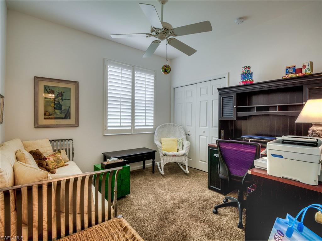 Carpeted home office featuring ceiling fan
