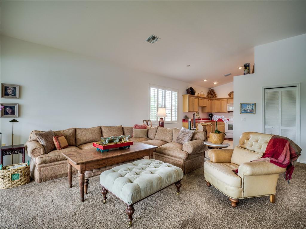 Living area featuring lofted ceiling and light colored carpet