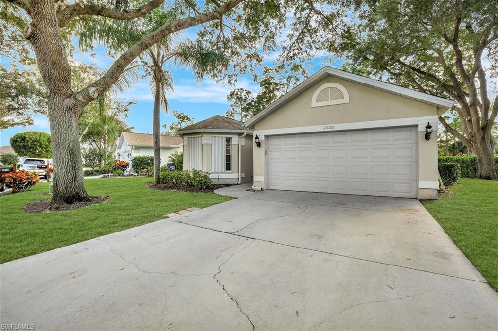 Ranch-style house featuring stucco siding, driveway, a front lawn, and an attached garage