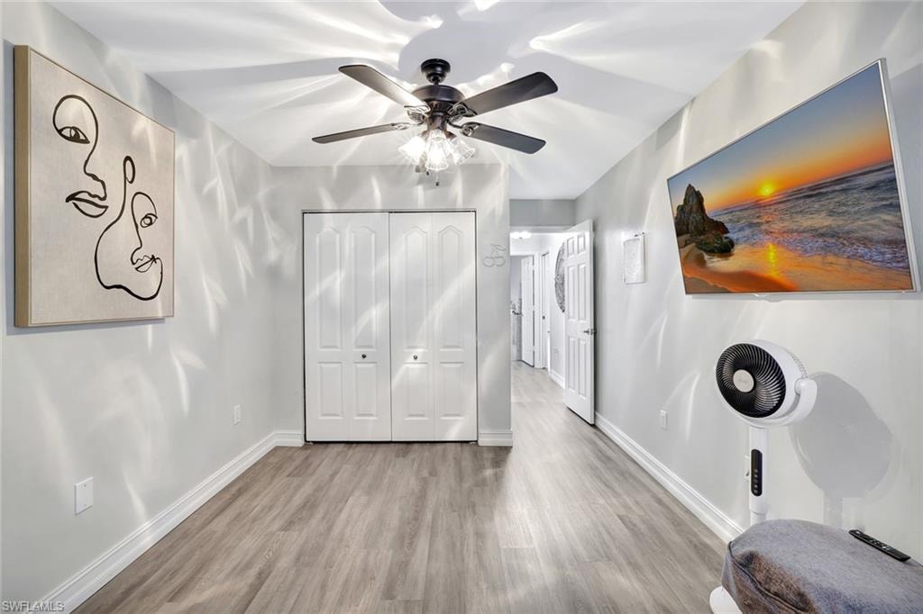Bedroom featuring wood finished floors, a closet, and a ceiling fan