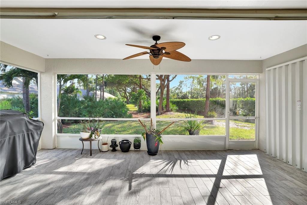 Sunroom with a ceiling fan, wood finished floors, and recessed lighting