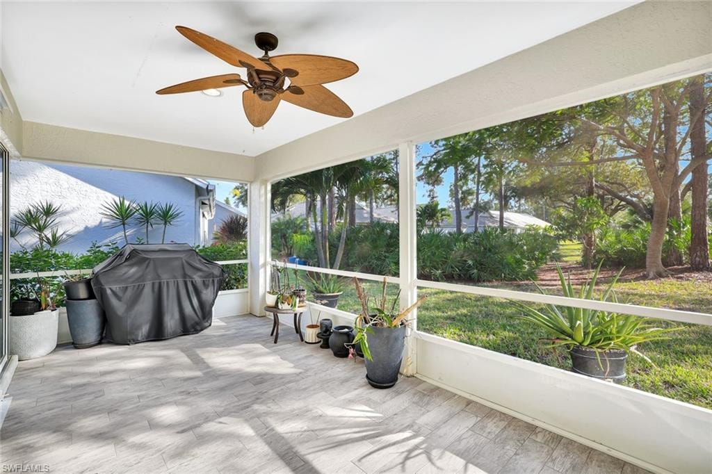 Unfurnished sunroom with ceiling fan and wood finished floors