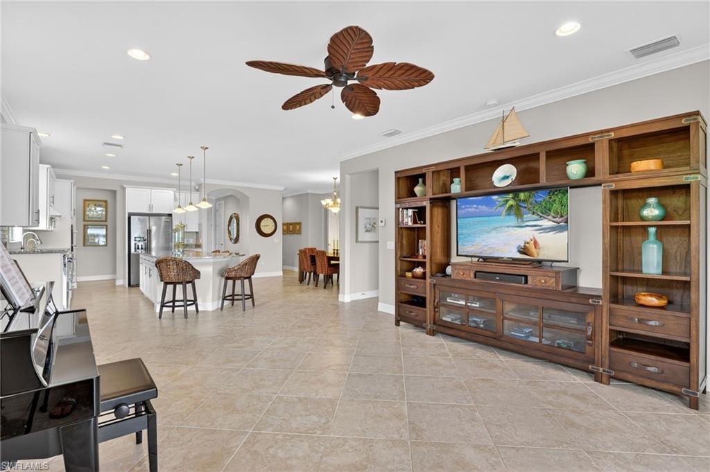 Living area featuring recessed lighting, crown molding, ceiling fan, and light tile patterned floors