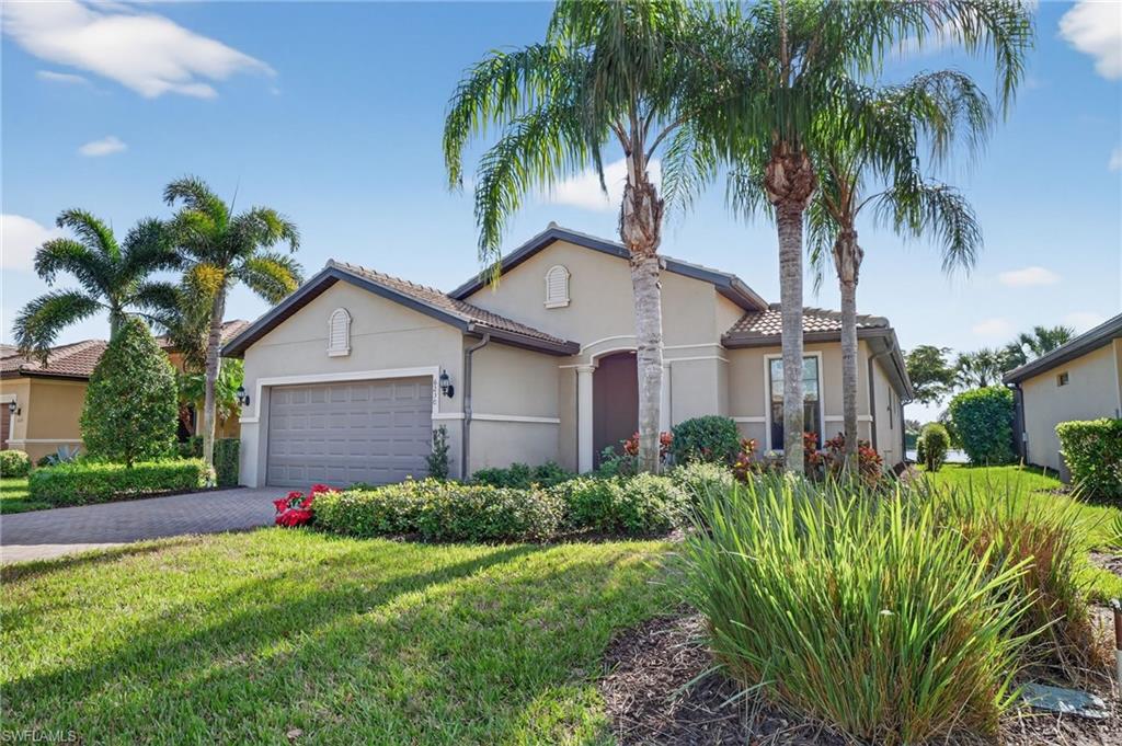 Mediterranean / spanish-style house featuring stucco siding, a front yard, decorative driveway, a garage, and a tile roof