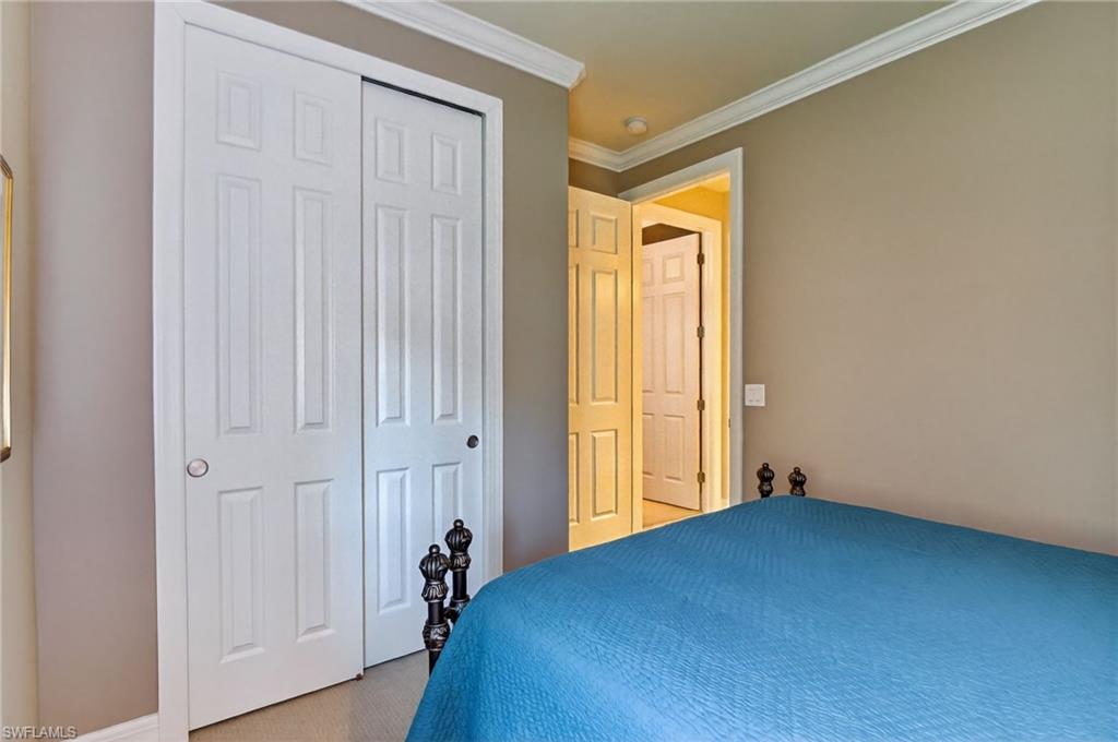 Bedroom with ornamental molding and a closet