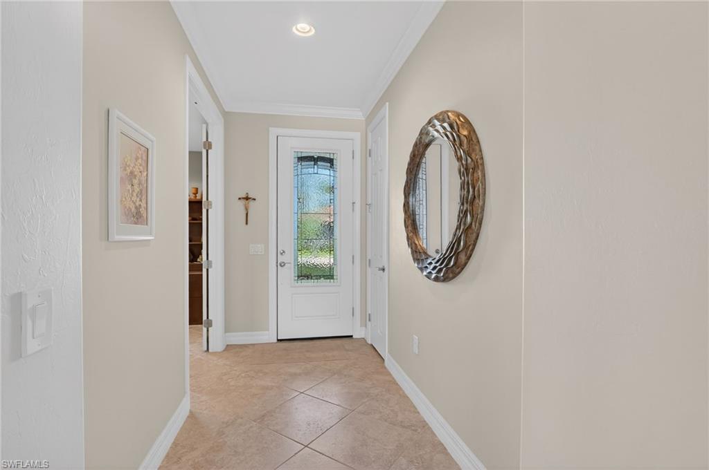 Doorway featuring crown molding and tile patterned floors