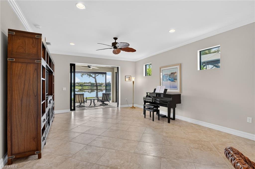 Sitting room featuring a water view, crown molding, recessed lighting, light tile patterned floors, and a ceiling fan