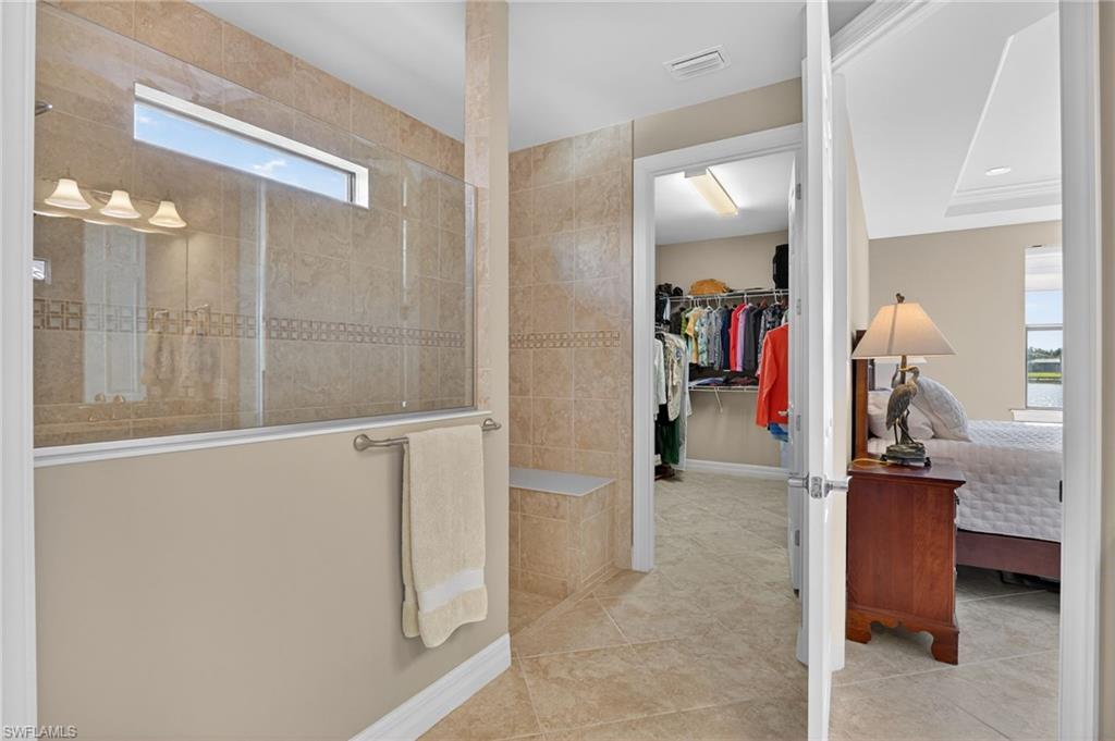Full bath with a walk in closet, a walk in shower, and tile patterned flooring