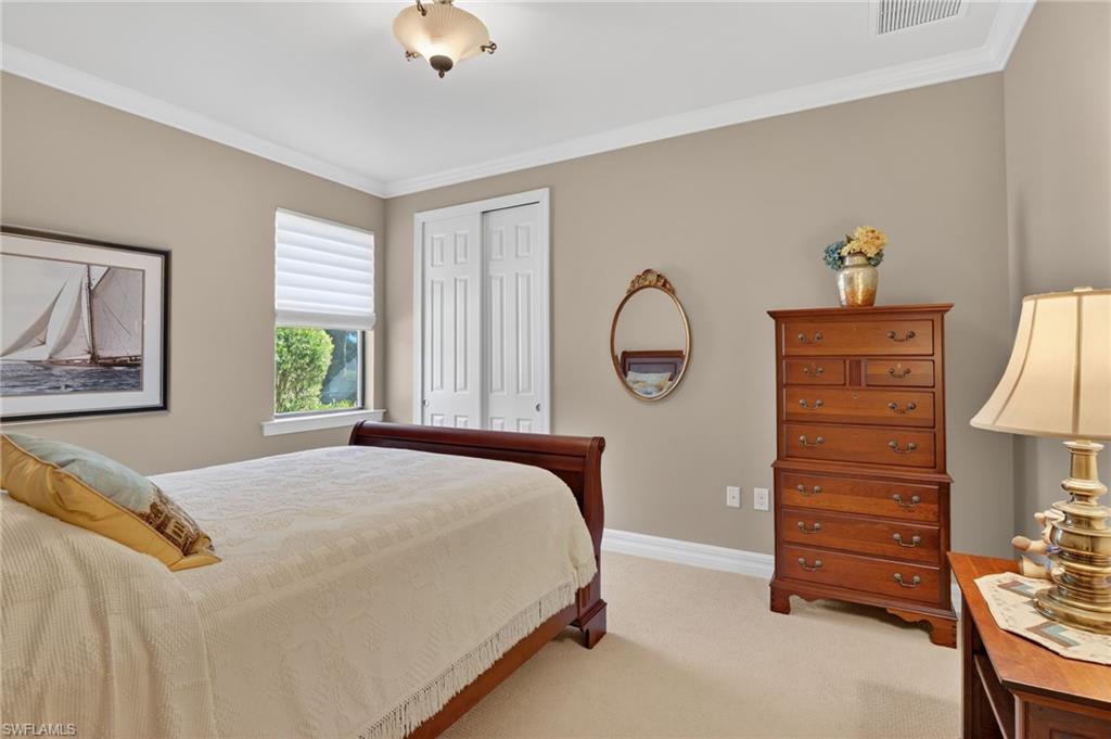 Bedroom featuring a closet, light carpet, and ornamental molding