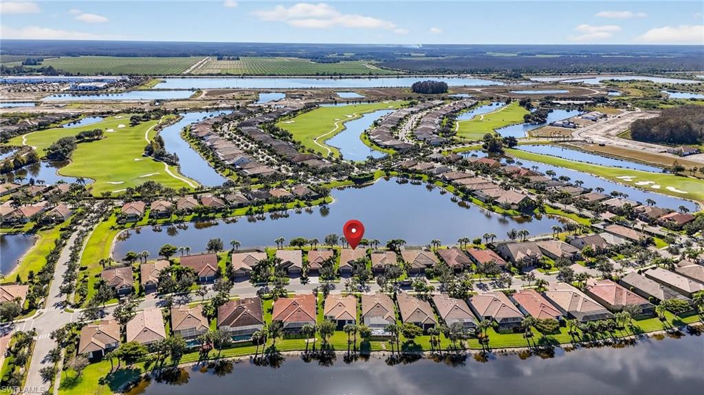 Aerial view of residential area with a nearby body of water and a golf club
