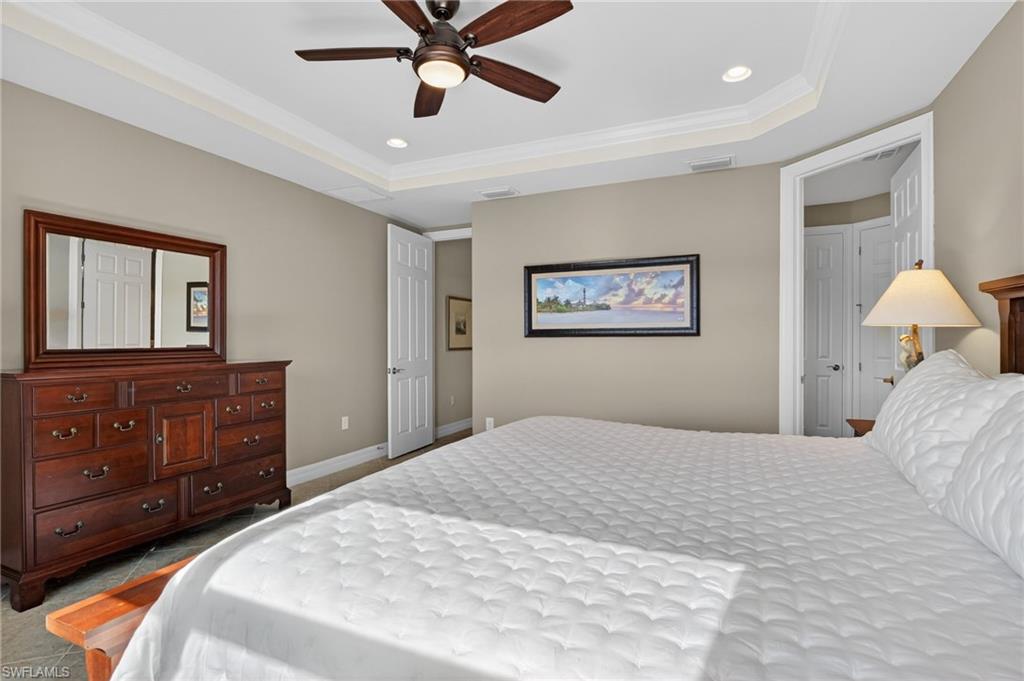 Bedroom featuring recessed lighting, ornamental molding, a ceiling fan, a tray ceiling, and light colored carpet