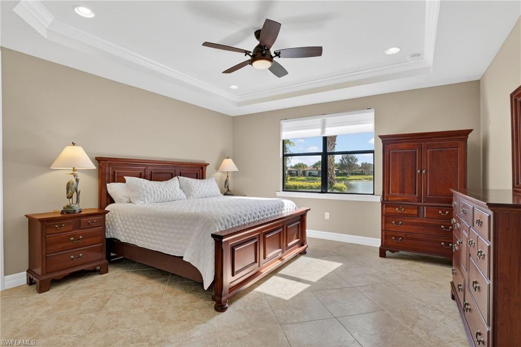 Bedroom featuring a ceiling fan, crown molding, a raised ceiling, recessed lighting, and light tile patterned floors