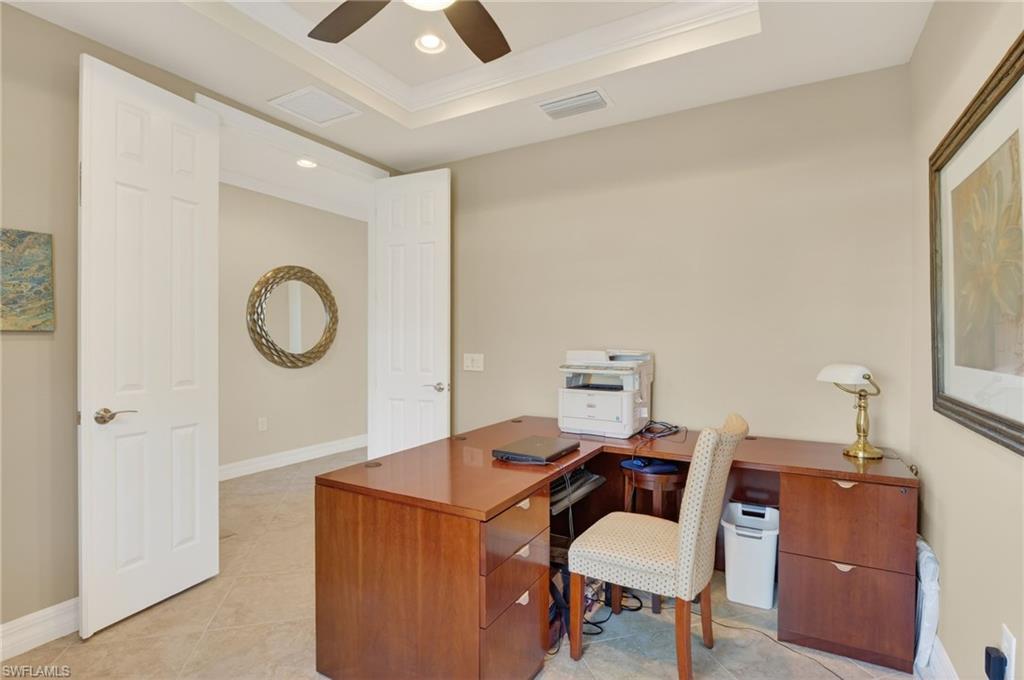 Home office featuring a raised ceiling, recessed lighting, crown molding, light tile patterned floors, and a ceiling fan