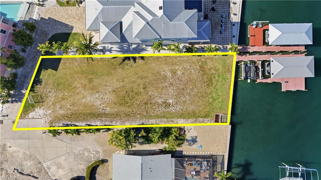 Aerial overview of property's location with property parcel outlined and a pool area - Virtually Edited Image