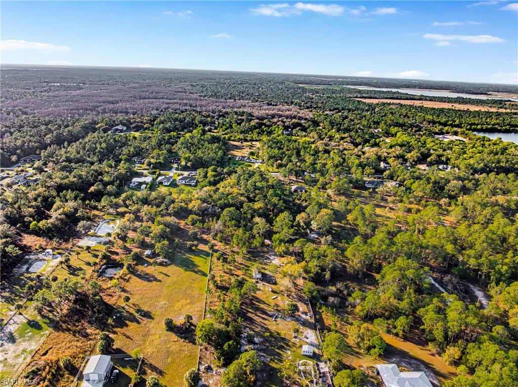 Aerial view of property and surrounding area with a forest