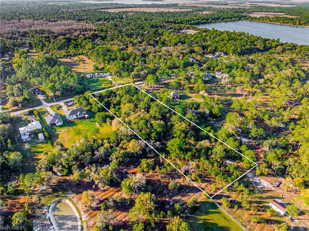 Aerial view of property and surrounding area with property boundaries highlighted and a forest
