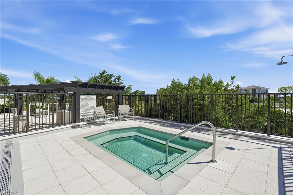 View of pool with a community hot tub and a patio area - Virtually Edited Image