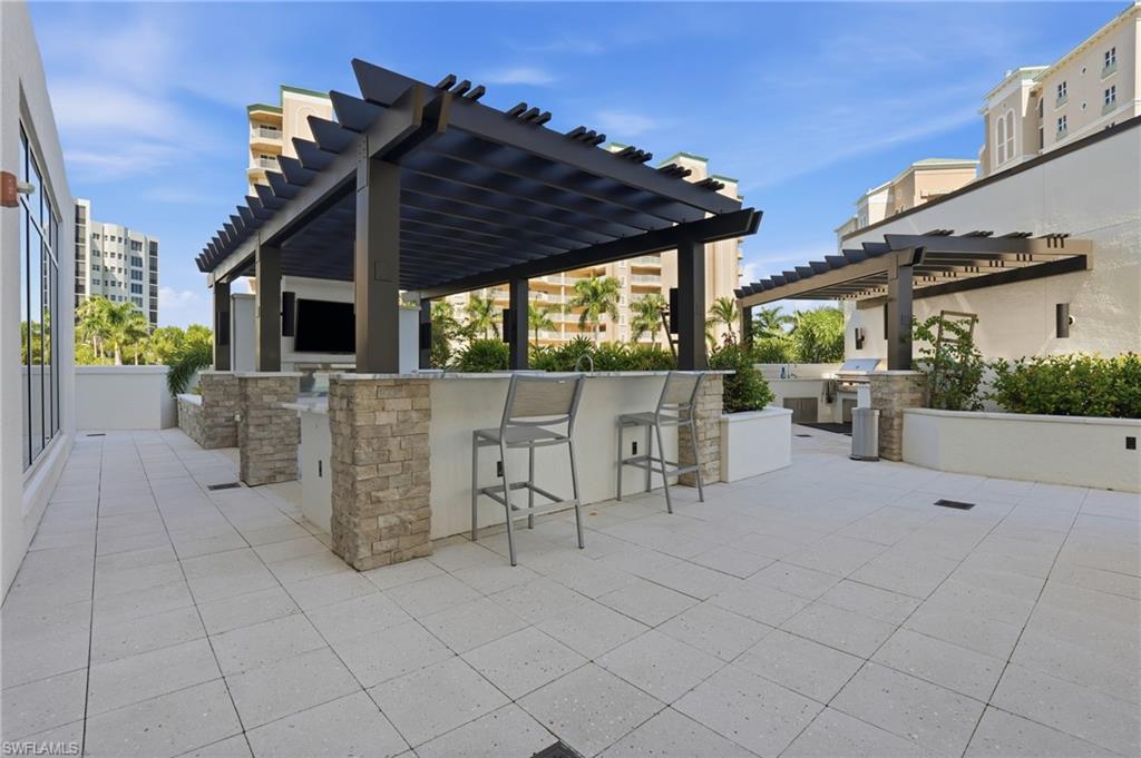 View of patio featuring area for grilling and a pergola - Virtually Edited Image