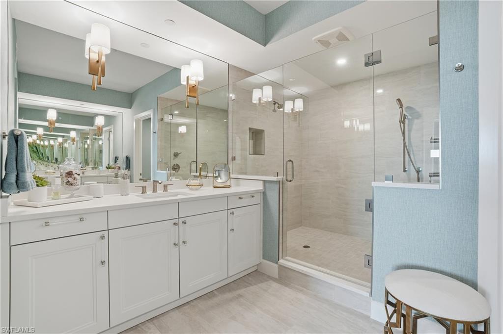 Bathroom with a stall shower, vanity, and a chandelier - Virtually Edited Image