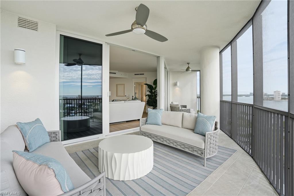 Sunroom featuring a wall of windows, an outdoor hangout area, plenty of natural light, a ceiling fan, and tile patterned floors - Virtually Edited Image