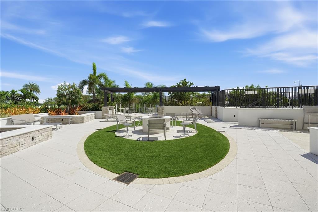 View of community featuring a fire pit and a patio area - Virtually Edited Image