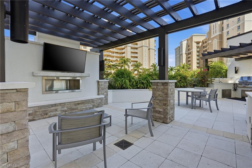 View of patio with a pergola, outdoor dining space, and an outdoor kitchen - Virtually Edited Image