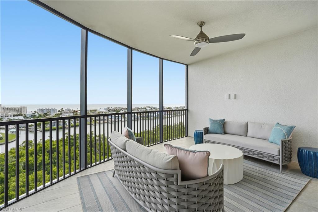 Sunroom with a water view, outdoor lounge area, and a ceiling fan - Virtually Edited Image